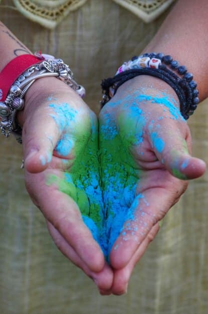 A close-up of hands gently holding a glowing green heart, symbolizing love, compassion, and connection to others for balancing the Heart Chakra.