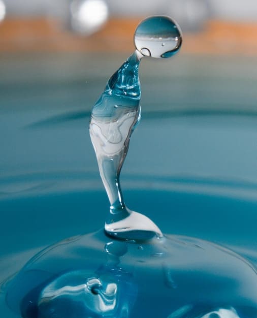 A close-up photo of a drop of water merging with the ocean, visually symbolizing the individual self merging with universal consciousness.
