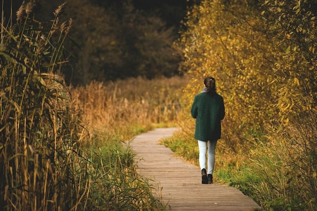 A person walking mindfully in nature, focusing on each step, with blurred surroundings, capturing the essence of being present and connected.