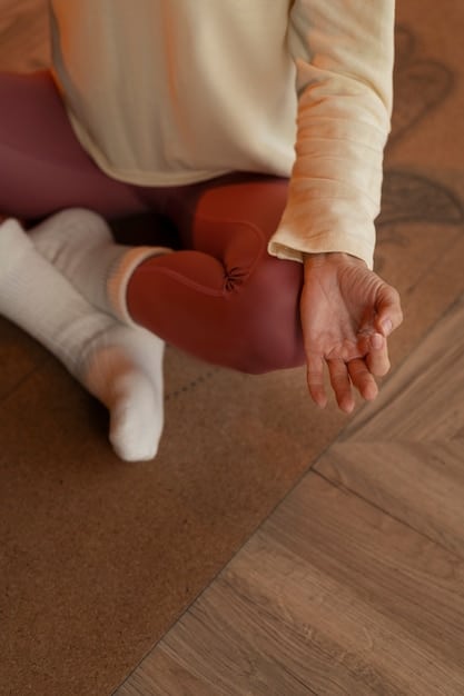 Close-up of hands resting gently on legs, symbolizing the start of a body scan meditation. The background is softly blurred, creating a calming and focused atmosphere.