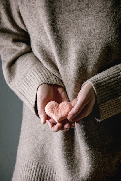 A close-up shot of hands gently cupping a glowing heart, representing the warmth and care cultivated through Loving-Kindness Meditation. The background is softly blurred, creating a sense of peace and tranquility.