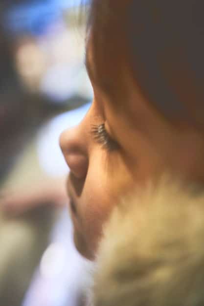 A close-up shot of a person's eyes closed in meditation, with rays of light softly illuminating their face, emphasizing concentration and inner peace.