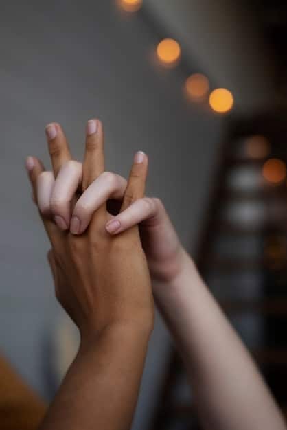Two hands gently touching, symbolizing connection and empathy. The background is blurred, focusing on the hands to emphasize the sense of care and understanding.