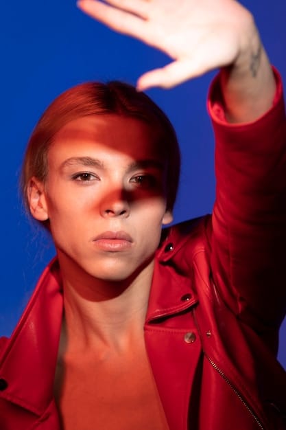 A close-up shot of a woman with fiery red hair, wearing a leather jacket and a bold red lipstick, embodying the confident and rebellious style of Aries.