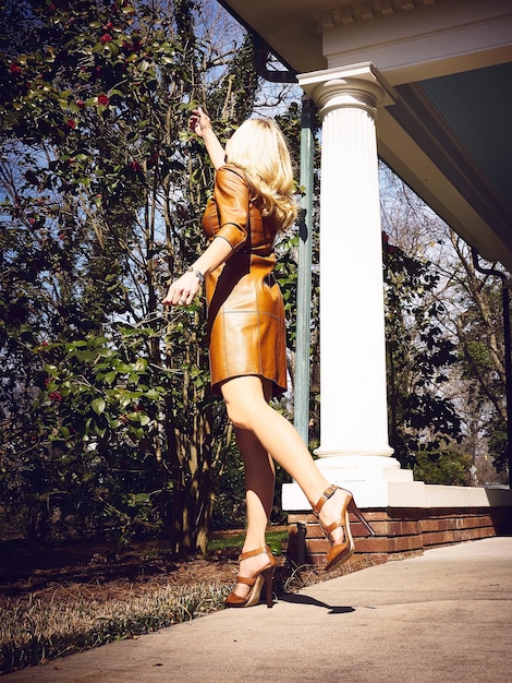 An image of a woman confidently walking down a city street, wearing a gold sequined dress and high heels, personifying the dramatic and luxurious style of Leo.