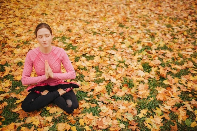 A serene image of a person meditating outdoors amidst autumn leaves, symbolizing the practice of finding inner balance and harmony.