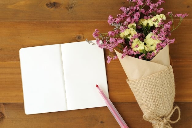 A journal open with handwritten affirmations about abundance, accompanied by a feather pen and a small vase of fresh flowers, placed on a wooden desk under natural light.