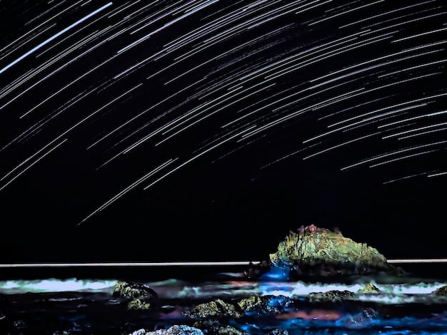 A close-up view of bright meteors streaking across a dark night sky during the peak of a meteor shower. The background is filled with countless stars, and the meteors leave glowing trails as they burn up in the atmosphere.
