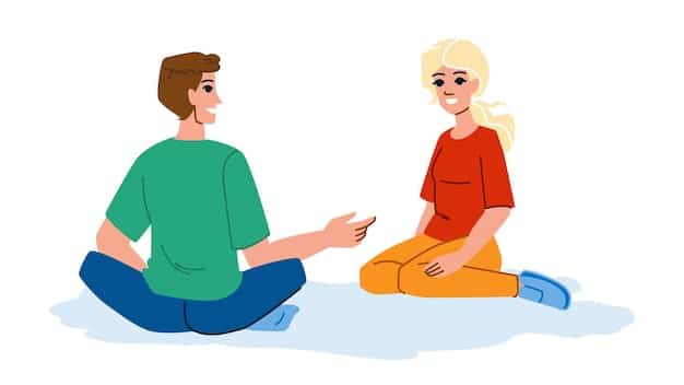 A couple sitting face-to-face, holding hands and looking at each other attentively, symbolizing active listening and open communication.