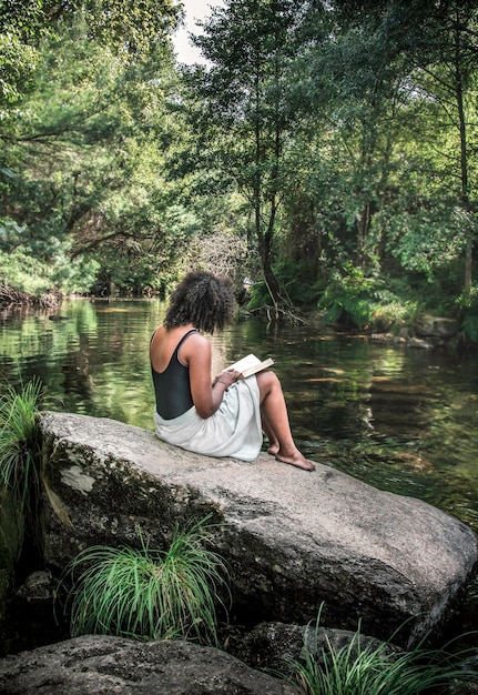 A person sitting in a peaceful garden, journaling and reflecting on their inner self. The scene should convey a sense of tranquility, contemplation, and self-discovery.