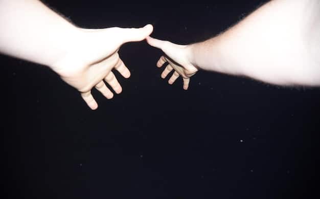 Two hands reaching out to each other, symbolizing reconciliation and the bridging of divides through forgiveness. The background is softly blurred, emphasizing the connection.