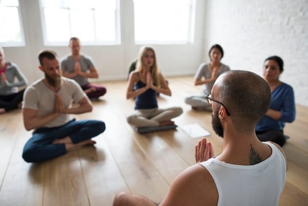 A group of people attending a Transcendental Meditation class. They are sitting comfortably, listening attentively to the instructor. The atmosphere is calm and supportive.