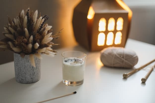 A clean, minimalist space is set up for meditation. A lit candle is placed on a small table at eye level, with a meditation cushion positioned comfortably on the floor in front of it. The room is dimly lit, creating a serene atmosphere.