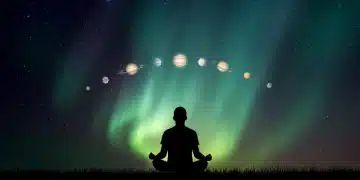 Person meditating under a starry sky with aurora and planetary alignment, symbolizing cosmic connection and spiritual growth.