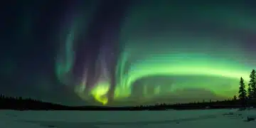 Stunning Aurora Borealis display over a serene northern US landscape