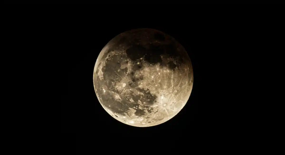 Close-up of moon during partial lunar eclipse with Earth's shadow visible.